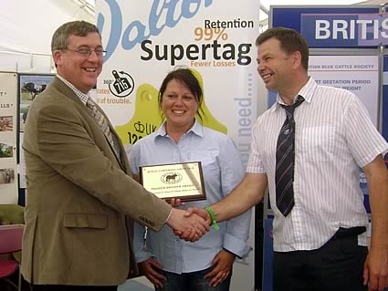 Tudur Wynne, Dalton ID Systems, presents the Premier Breeder & Premier Exhibitor award to Jeff and Lorraine Dunn of the Highridge Blues Herd
